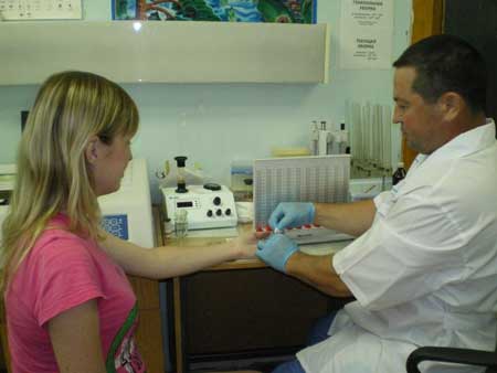 врач берет кровь из пальца