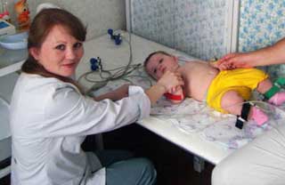 врач делает ЭКГ ребенку