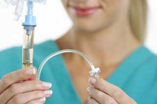 врач настраивает капельницу