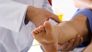 врач осматривает вены на ногах